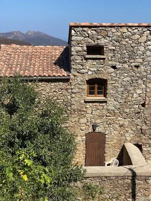a stone building with a door and a window at Casa Padume - Maison de village en Balagne in Nessa