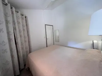 a white bedroom with a bed and curtains at ST CYPRIEN A6 5 pers à 250m de la plage de sable Saint Cyprien in Lecci