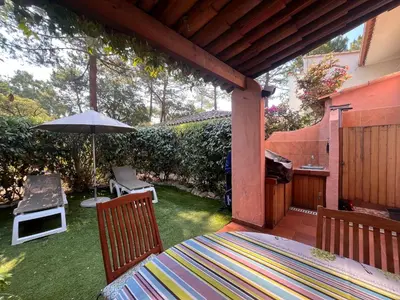 a patio with a table and an umbrella on a lawn at ST CYPRIEN A6 5 pers à 250m de la plage de sable Saint Cyprien in Lecci