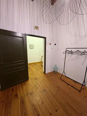 a room with a black door and a wooden floor at Ferme auberge U sapè fà in Saliceto