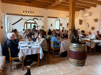 a group of people sitting at tables in a restaurant at Ferme auberge U sapè fà in Saliceto