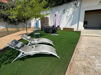 a house with a lawn with chairs on it at Bas de villa 80m2 secteur Ajaccio in Tavaco