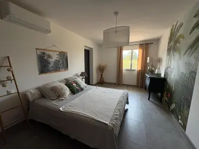 a bedroom with a large bed in a room at Bas de villa 80m2 secteur Ajaccio in Tavaco