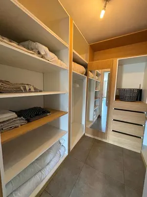 a walk in closet with wooden shelves and a mirror at Bas de villa 80m2 secteur Ajaccio in Tavaco