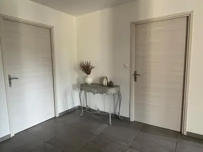 a room with two doors and a table with a plant at Bas de villa 80m2 secteur Ajaccio in Tavaco