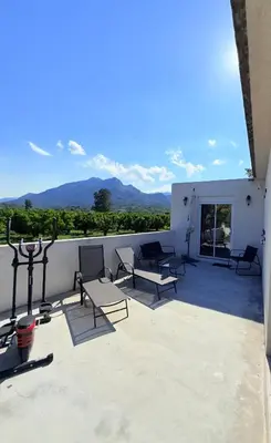 a balcony with chairs and a view of mountains at Studio vue sur les clémentiniers in Santa-Lucia-di-Moriani
