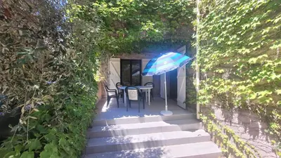 a patio with a table and an umbrella at Location de vacances in Santa-Maria-Poggio
