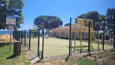 a batting cage at a park with a building at Location de vacances in Santa-Maria-Poggio