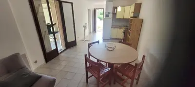 a kitchen and a table and chairs in a room at Location de vacances in Santa-Maria-Poggio