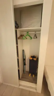 a room with a closet with a bed and a suitcase at Location de vacances in Santa-Maria-Poggio