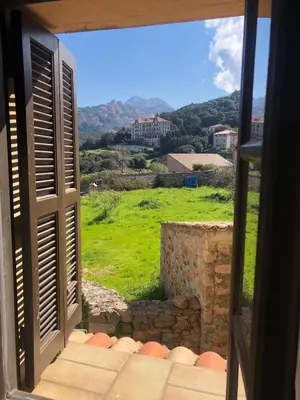 an open window with a view of a green field at T3 en duplex au cœur de Piana in Piana