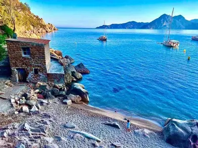 a stone house on the shore of a body of water at T3 en duplex au cœur de Piana in Piana