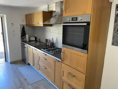 a kitchen with wooden cabinets and a stove top oven at T3 en duplex au cœur de Piana in Piana