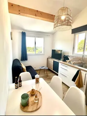 a small living room with a table and chairs at Appartement avec terrasse privée et piscine in Sarrola-Carcopino