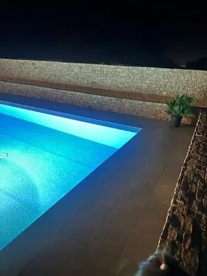 a swimming pool at night with blue lights at Appartement avec terrasse privée et piscine in Sarrola-Carcopino