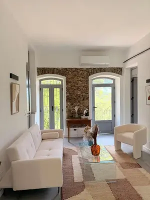 a living room with a white couch and a table at Demeure de charme, appartement du Campu di l altru mondu in San-Giuliano