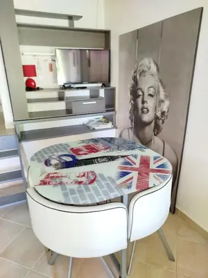 a table in a kitchen with a picture of a woman at studio piscine en Haute Corse in Venzolasca