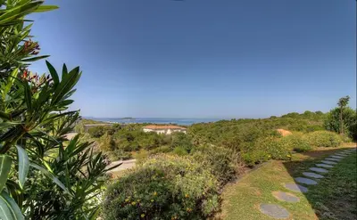 a garden with a view of the ocean at Rez de villa vue mer panoramique in Albitreccia