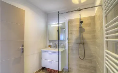 a bathroom with a glass shower and a sink at Rez de villa vue mer panoramique in Albitreccia