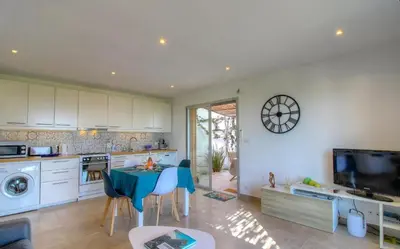 a kitchen with a table and a dining room at Rez de villa vue mer panoramique in Albitreccia