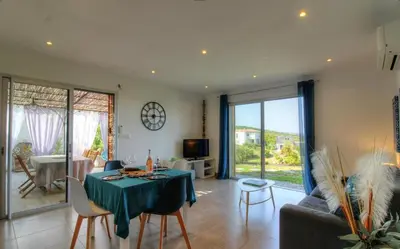 a living room with a table and a couch at Rez de villa vue mer panoramique in Albitreccia