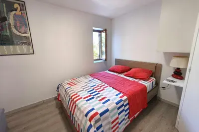 a bedroom with a bed with red pillows on it at Spacious villa with pool and sea views in Villanova