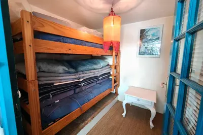 a bunk bed in a small room with pink sheets at Spacious villa with pool and sea views in Villanova