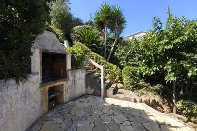 a chair sitting on a patio outside of a house at Spacious villa with pool and sea views in Villanova