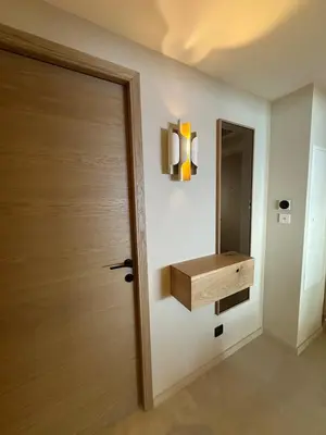 a bathroom with a wooden door and a mirror at Appartement exceptionnel vue mer in Ajaccio