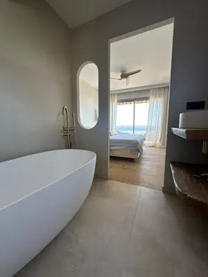 a bathroom with a large white tub and a bedroom at Appartement exceptionnel vue mer in Ajaccio
