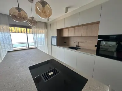 a kitchen with white cabinets and a black counter top at Appartement exceptionnel vue mer in Ajaccio