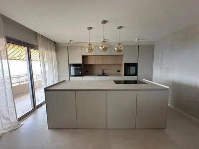 a kitchen with white cabinets and a large island at Appartement exceptionnel vue mer in Ajaccio