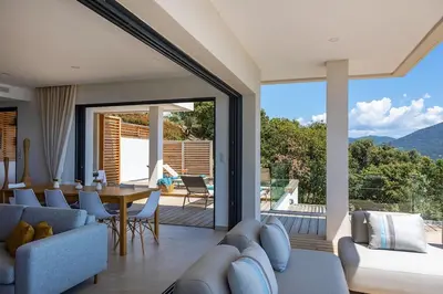 a living room with a couch and a table with chairs at Villa Lalie in Olmeto