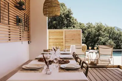 a table with plates and glasses on a deck at Villa Lalie in Olmeto