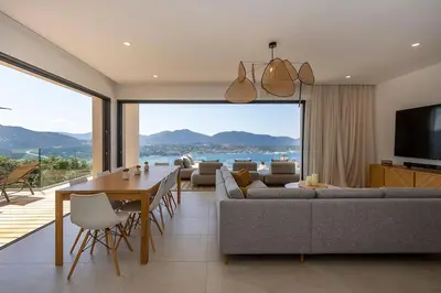 a living room with a table and a large window at Villa Lalie in Olmeto