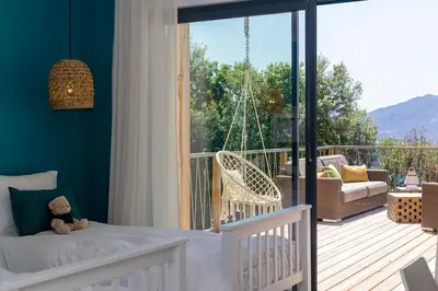 a bedroom with a swinging bed on a balcony at Villa Lalie in Olmeto