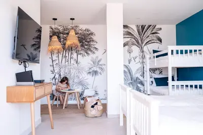 a girl sitting at a desk in a bedroom with palm trees mural at Villa Lalie in Olmeto