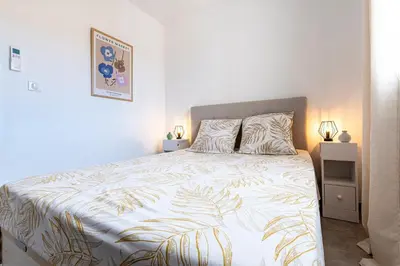 a bedroom with a large bed with a white bedspread at L'Île de Beauté - Climatisé in Pietrosella