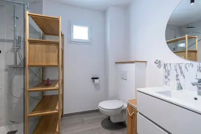 a bathroom with a toilet and a sink and a mirror at L'Île de Beauté - Climatisé in Pietrosella