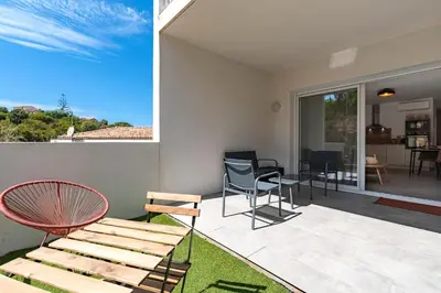 a room with a patio with chairs and a table at L'Île de Beauté - Climatisé in Pietrosella