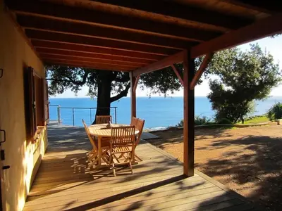 a wooden deck with a table and chairs on it at La Colline by Pinarello Villa Services in Fautea