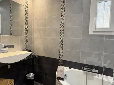 a bathroom with a white tub and a sink at La Colline by Pinarello Villa Services in Fautea