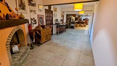 a living room with a fireplace and a hallway at Grand T2 duplex, terrasse et jardin in Porto Ota