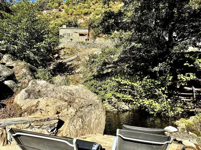 a group of chairs sitting next to a river at Bergerie in Volpajola