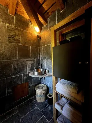 a bathroom with a sink in a stone wall at Bergerie in Volpajola