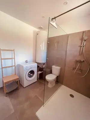 a bathroom with a toilet and a washing machine at Villa Poggiole in San-Nicolao