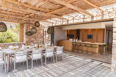 an outdoor patio with a table and chairs and a kitchen at Villa Bonanza Di Cala Rossa in Lecci