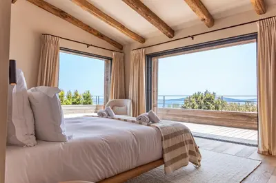 a bedroom with a large bed and a large window at Villa Bonanza Di Cala Rossa in Lecci