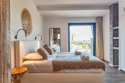 a bedroom with a large bed with a large window at Villa Fautea Di Santa Lucia in Sainte-Lucie de Porto-Vecchio