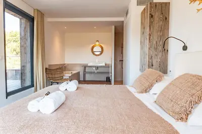 a bedroom with a large bed with towels on it at Villa Fautea Di Santa Lucia in Sainte-Lucie de Porto-Vecchio